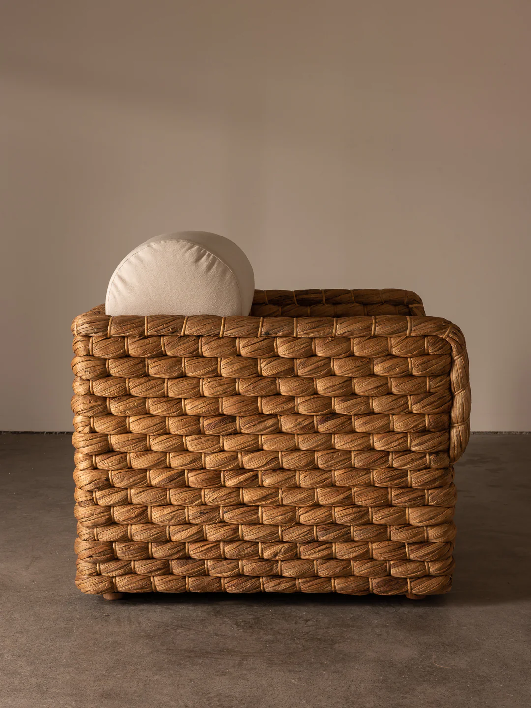 a brown basket with a white pillow on top of it