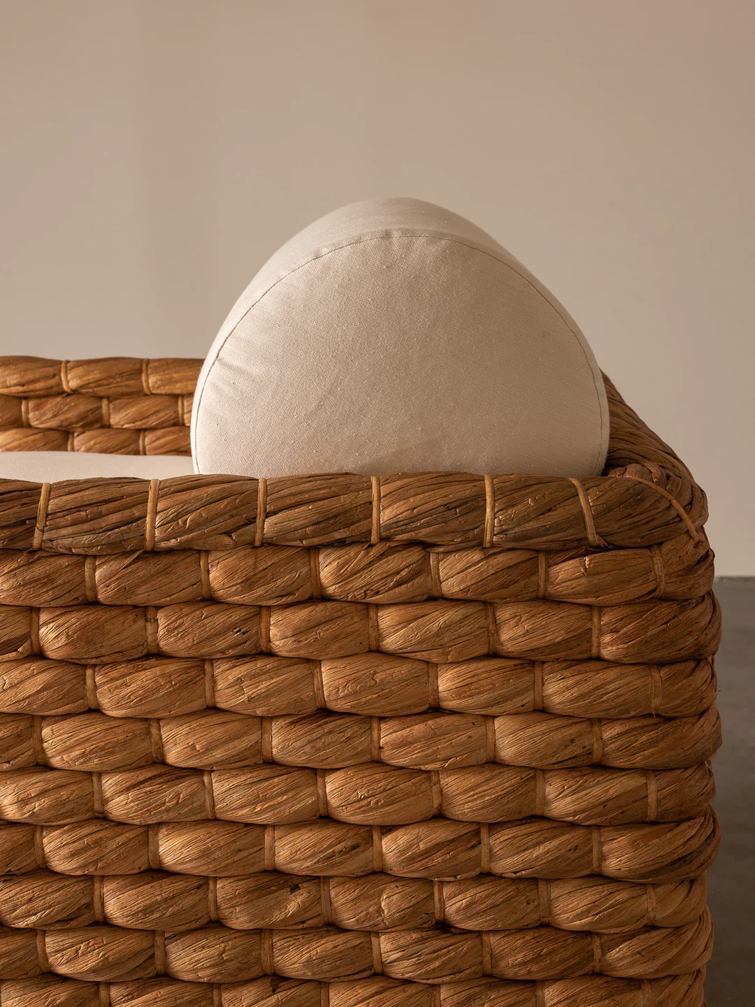 a white pillow sitting on top of a woven basket
