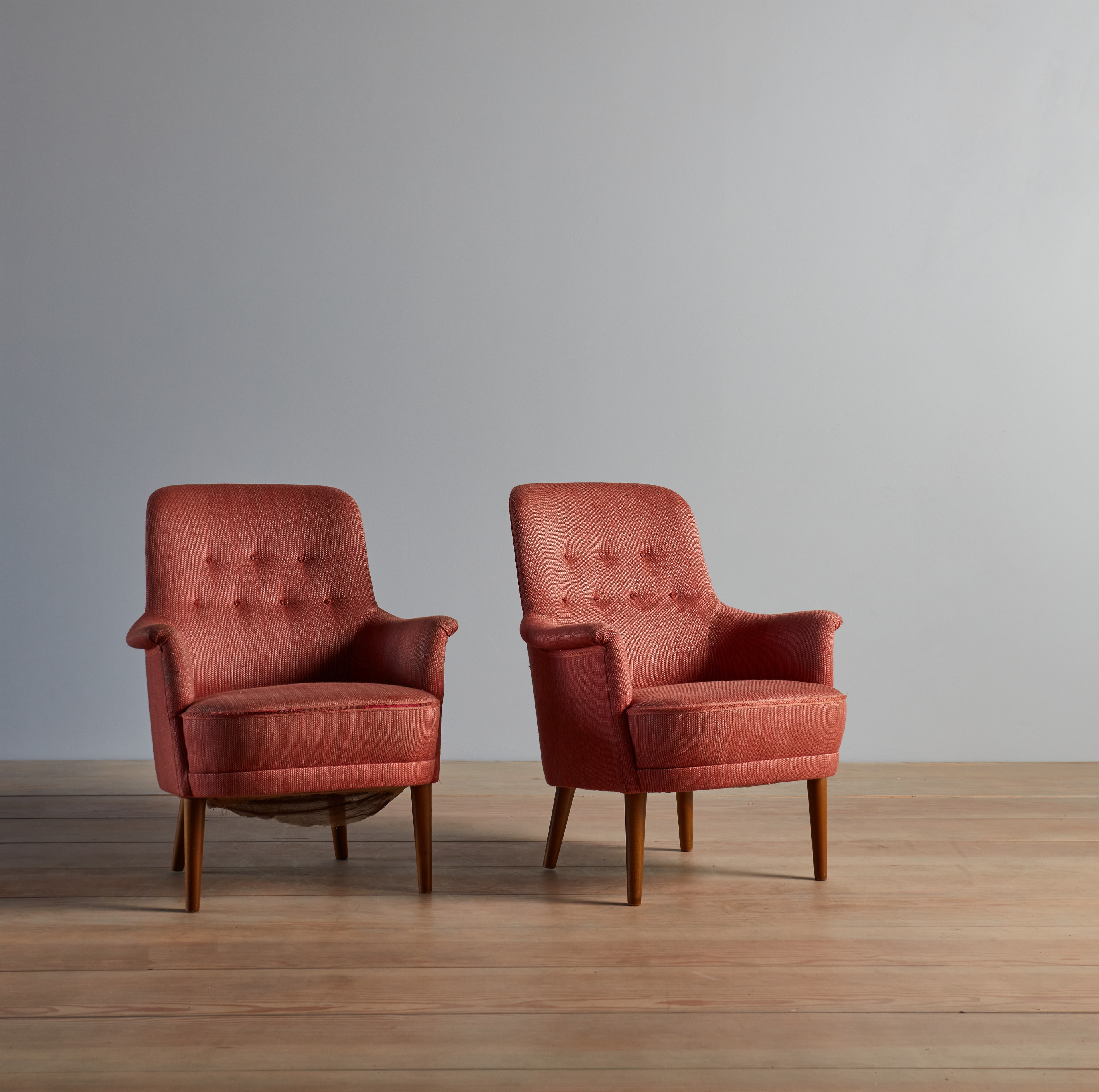 a pair of red chairs sitting on top of a wooden floor