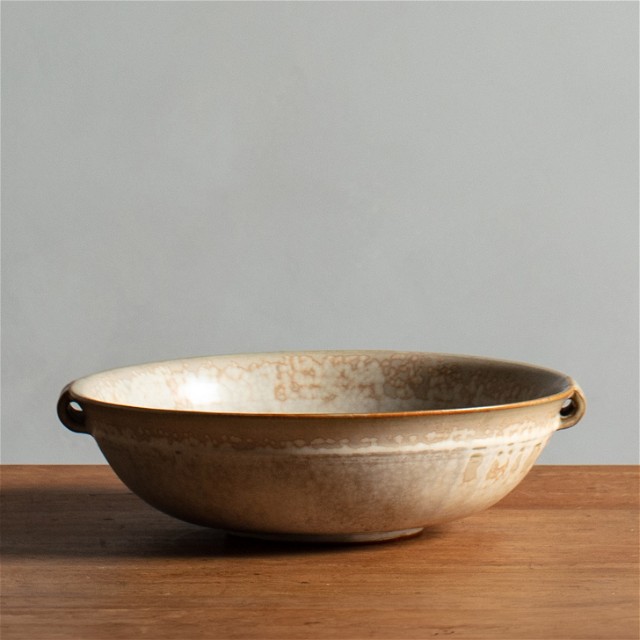a brown bowl sitting on top of a wooden table
