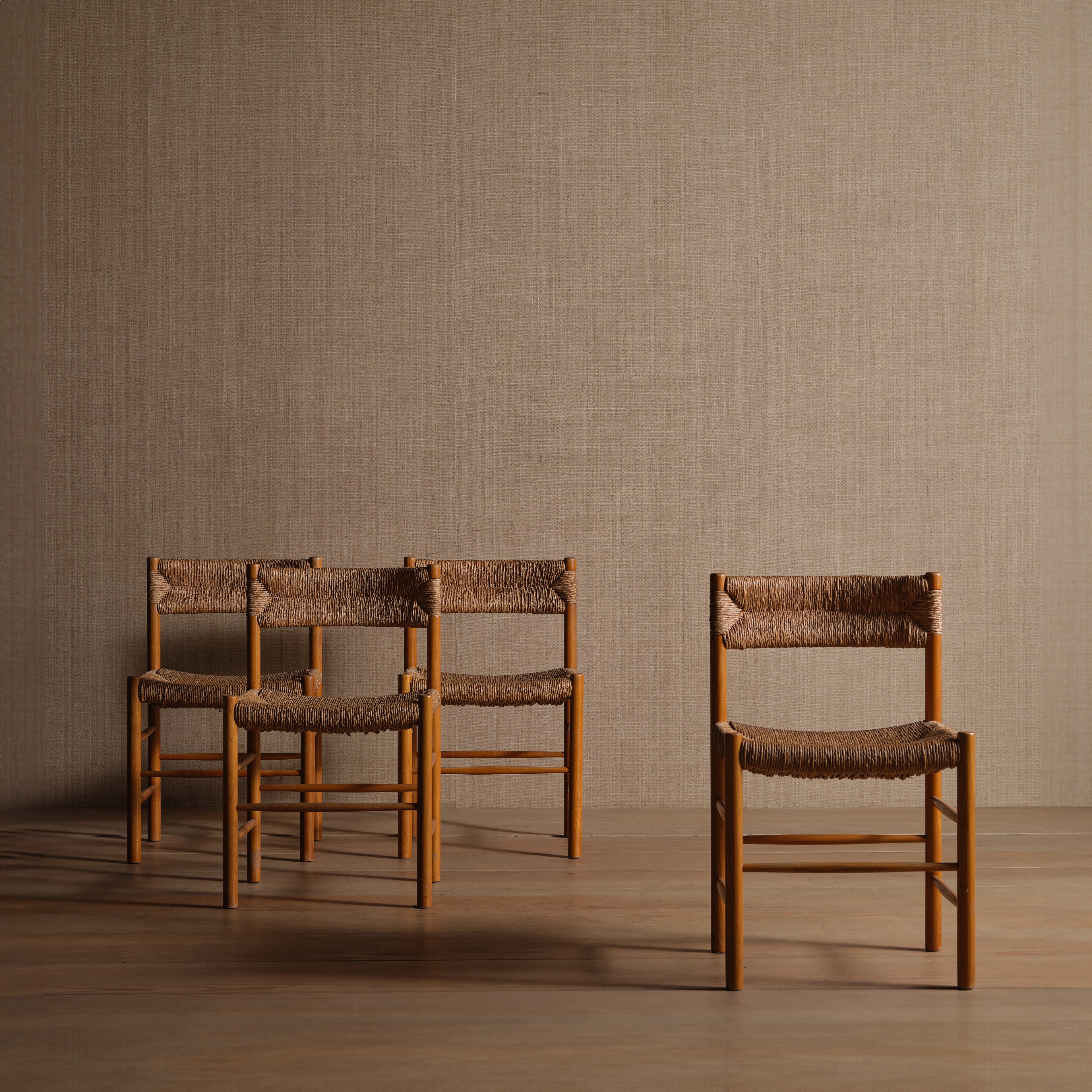 a group of four chairs sitting on top of a wooden floor