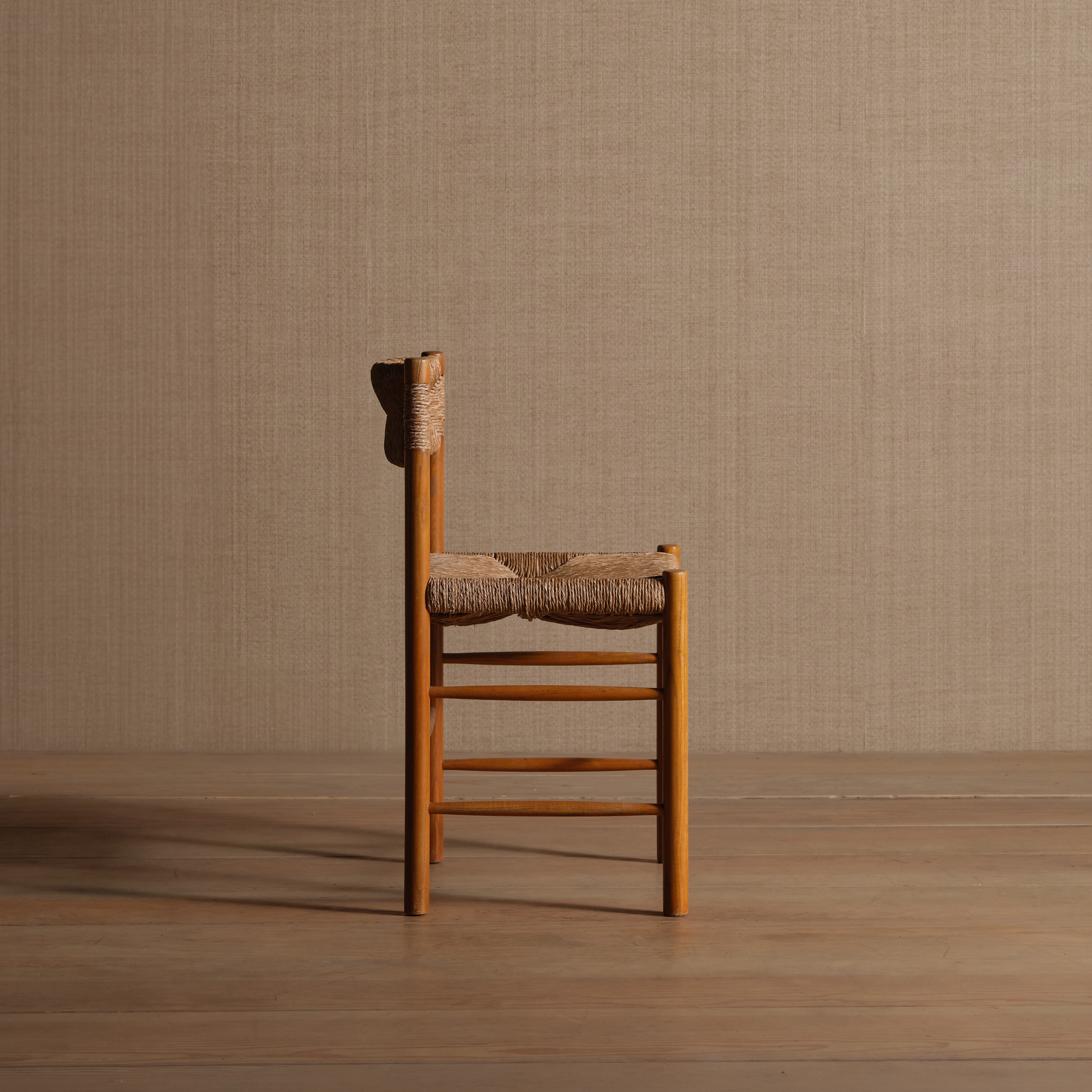 a wooden chair with a woven seat on a wooden floor