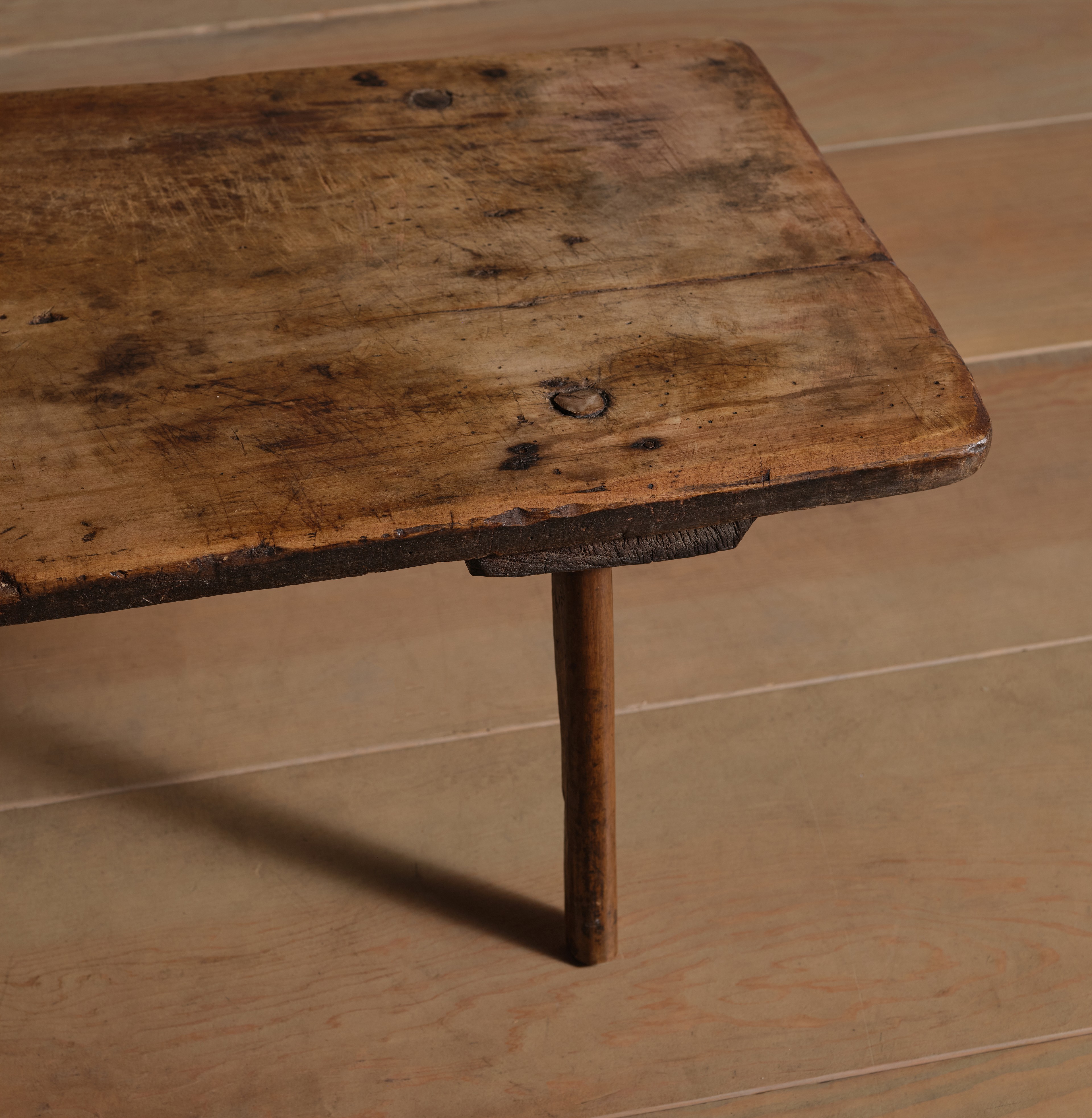 an old wooden table on a tile floor