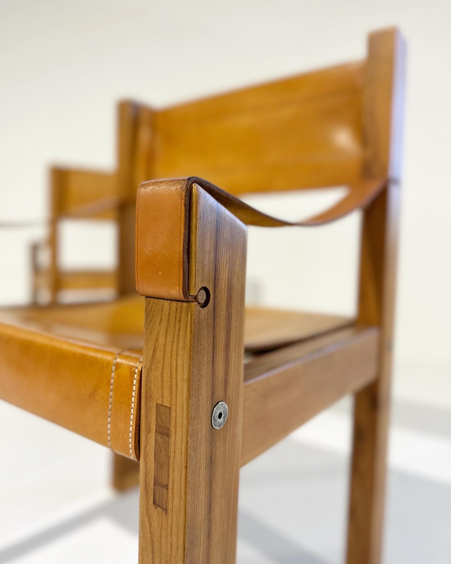a close up of a wooden chair with a leather seat