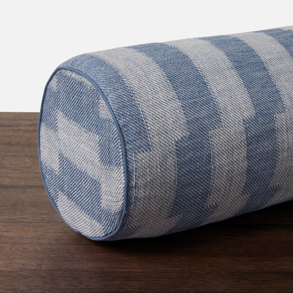 a blue and white striped pillow sitting on top of a wooden table