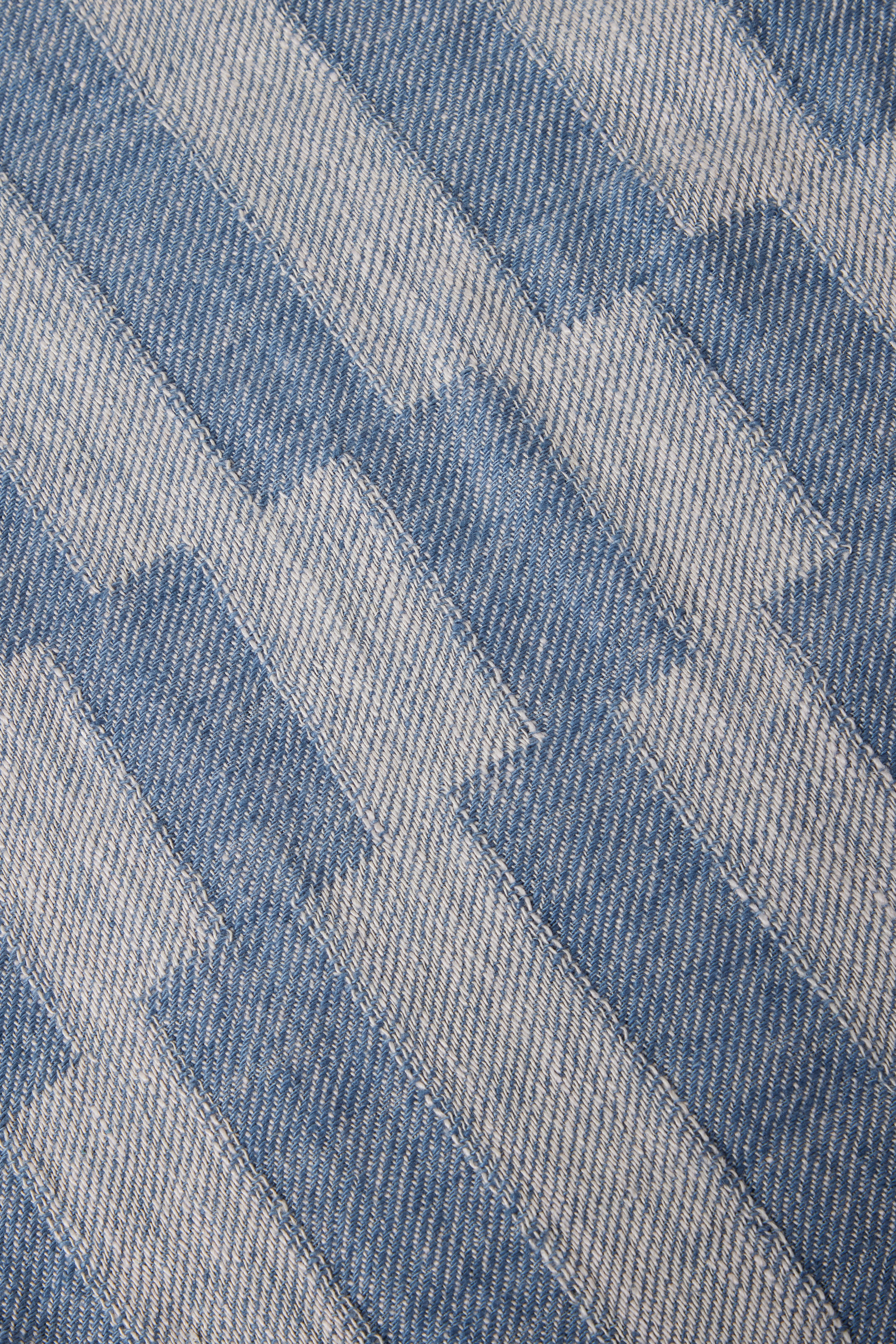 a close up of a blue and white striped rug