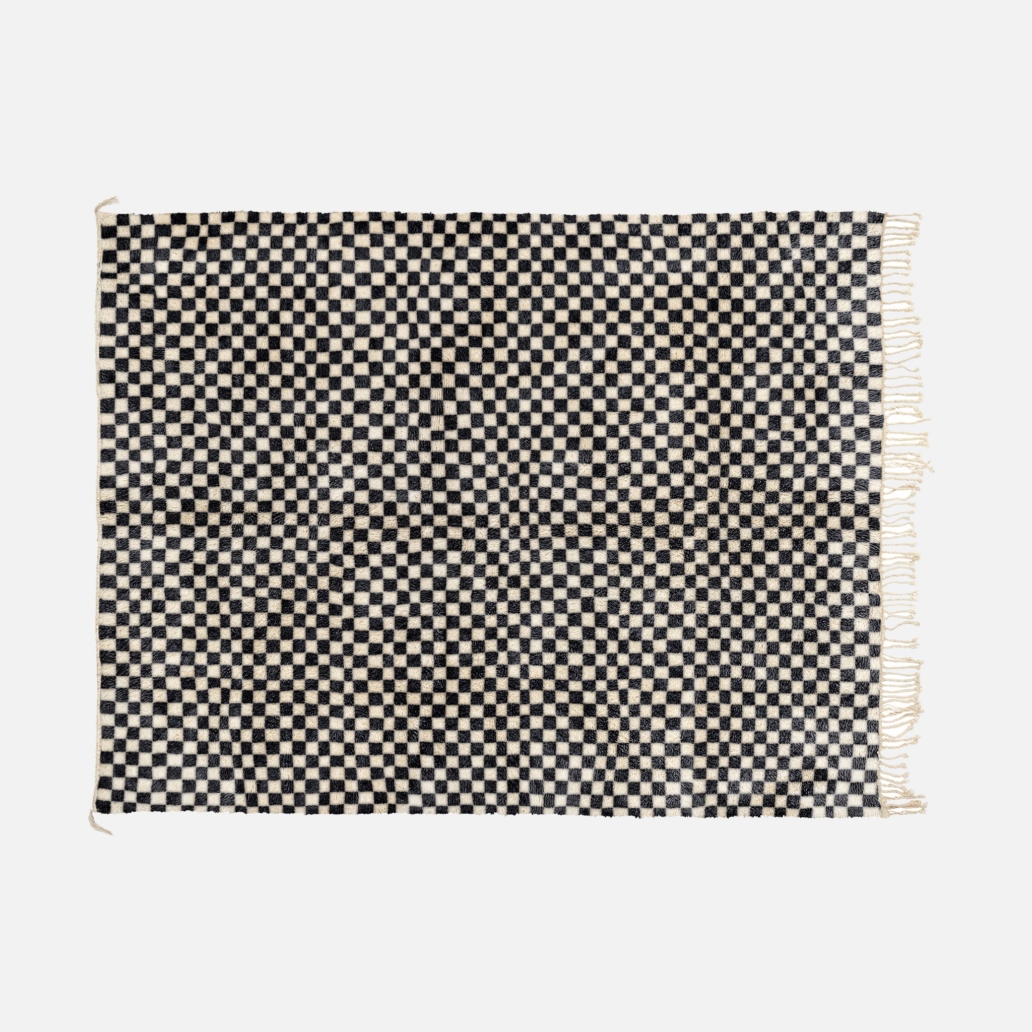 a black and white checkered rug with fringes