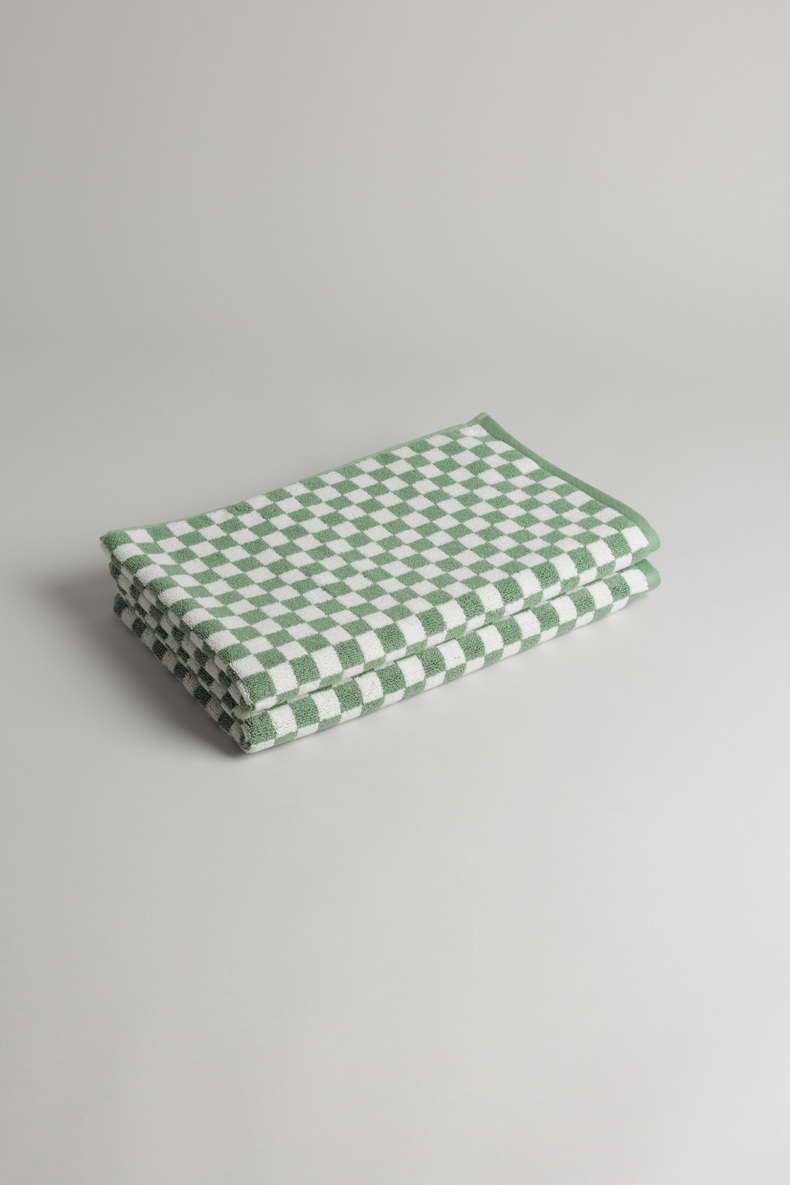 a green and white checkered napkin on a white surface