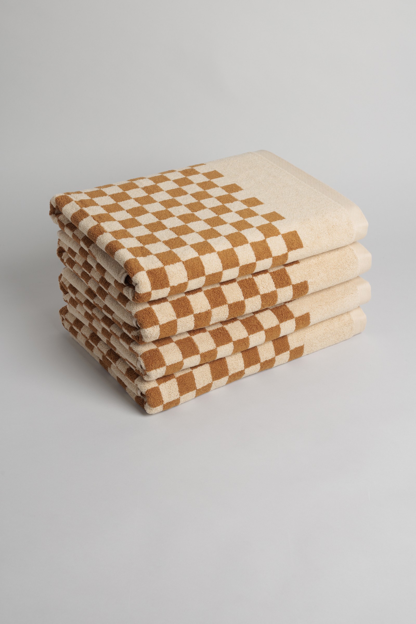 a stack of four brown and white checkered towels