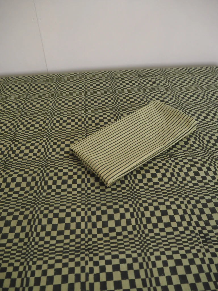 a black and white checkered bedspread with a striped pillow