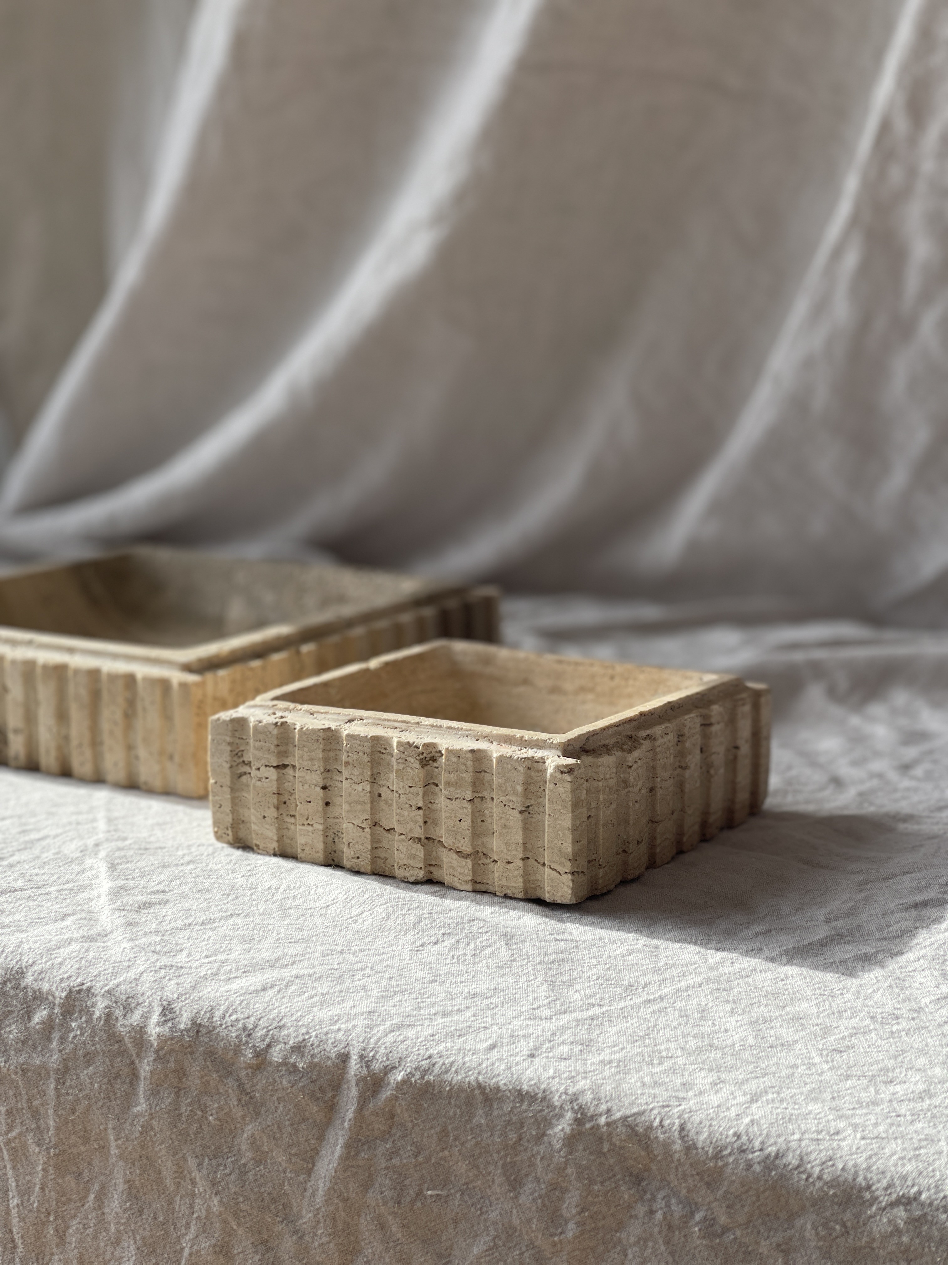 two wooden boxes sitting on top of a white sheet