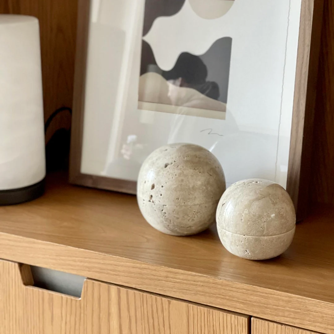 two white balls sitting on top of a wooden shelf