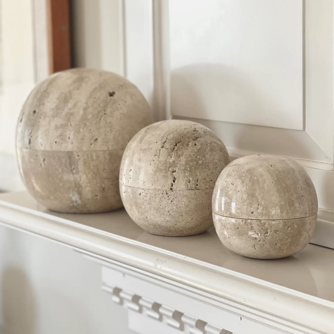 three cement balls sitting on top of a mantle