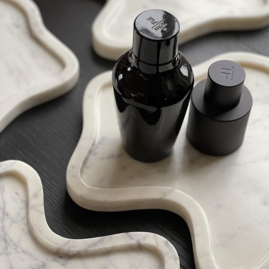 a bottle of cologne sitting on top of a marble tray