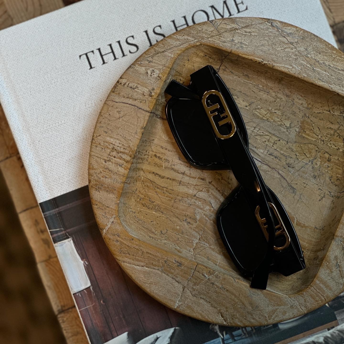 a pair of black sunglasses sitting on top of a wooden plate