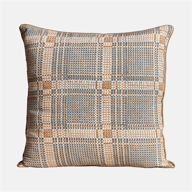 a blue and beige pillow with a checkered pattern