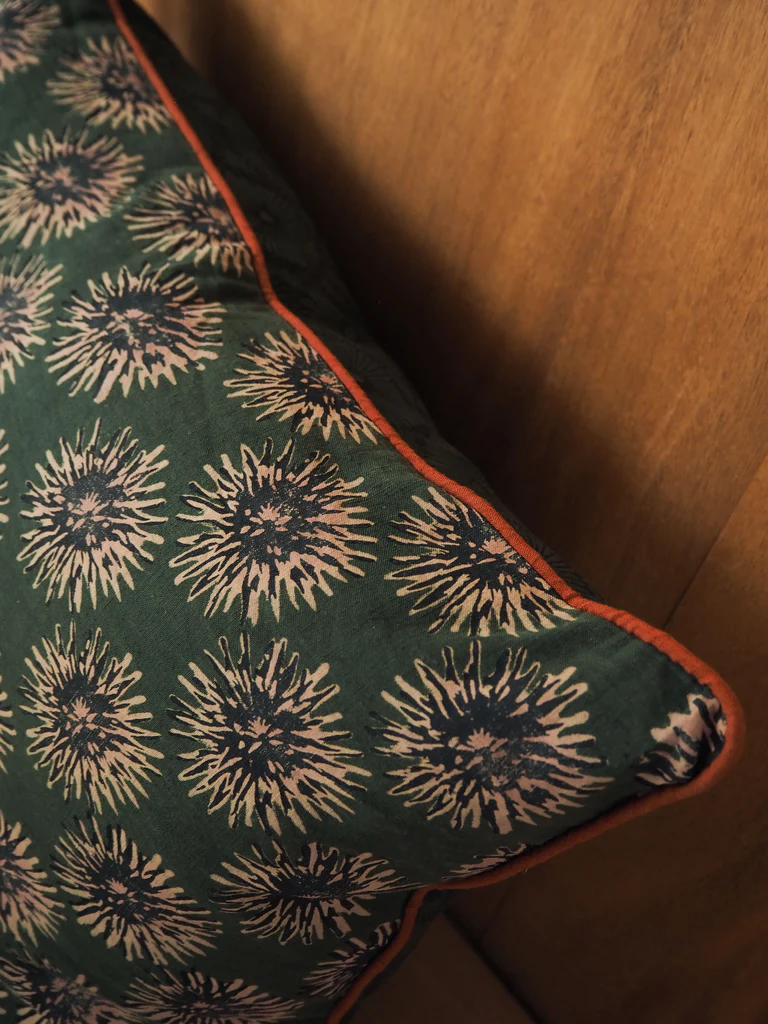 a close up of a pillow on a wooden surface