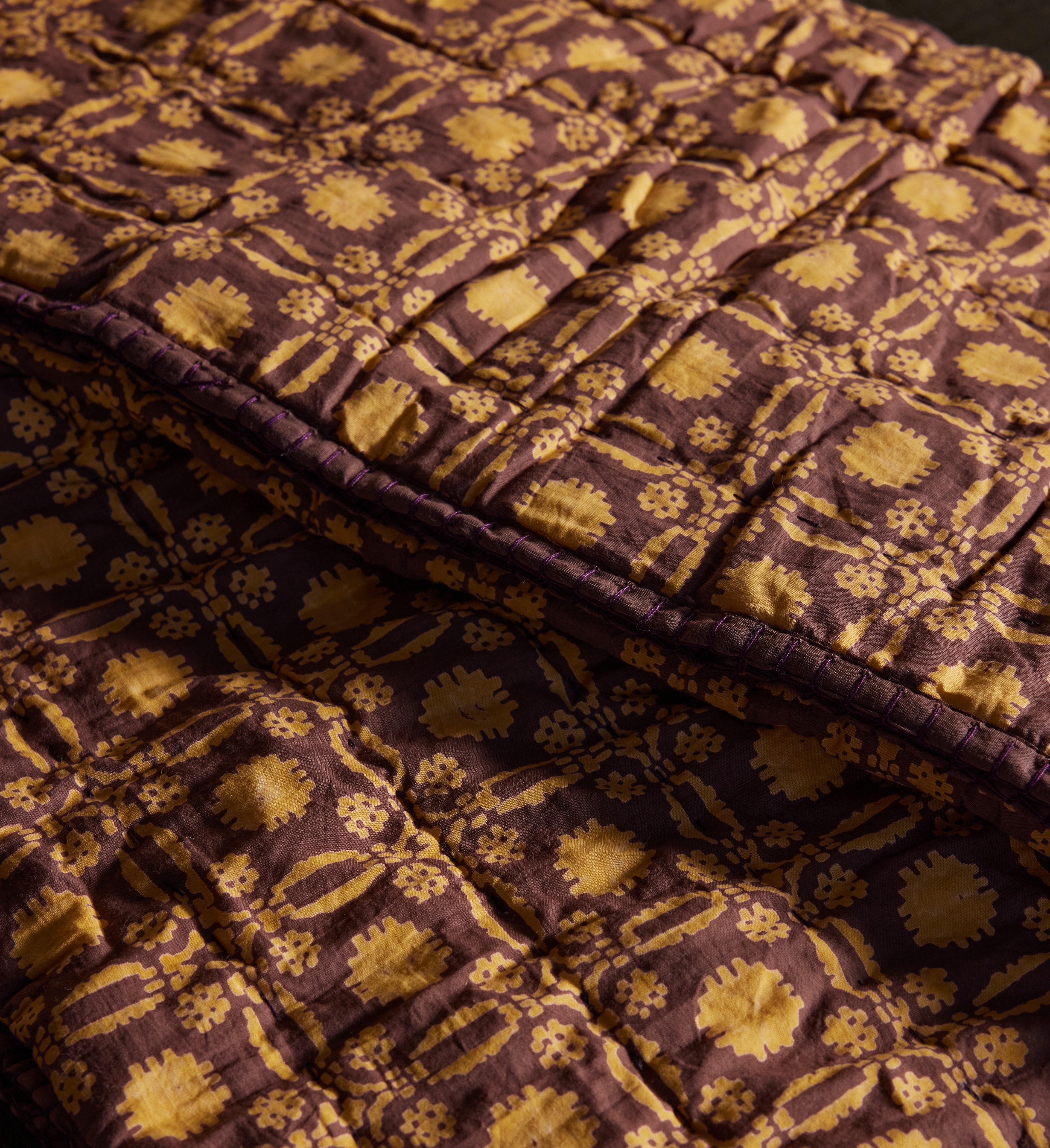 a close up of a purple and yellow quilt