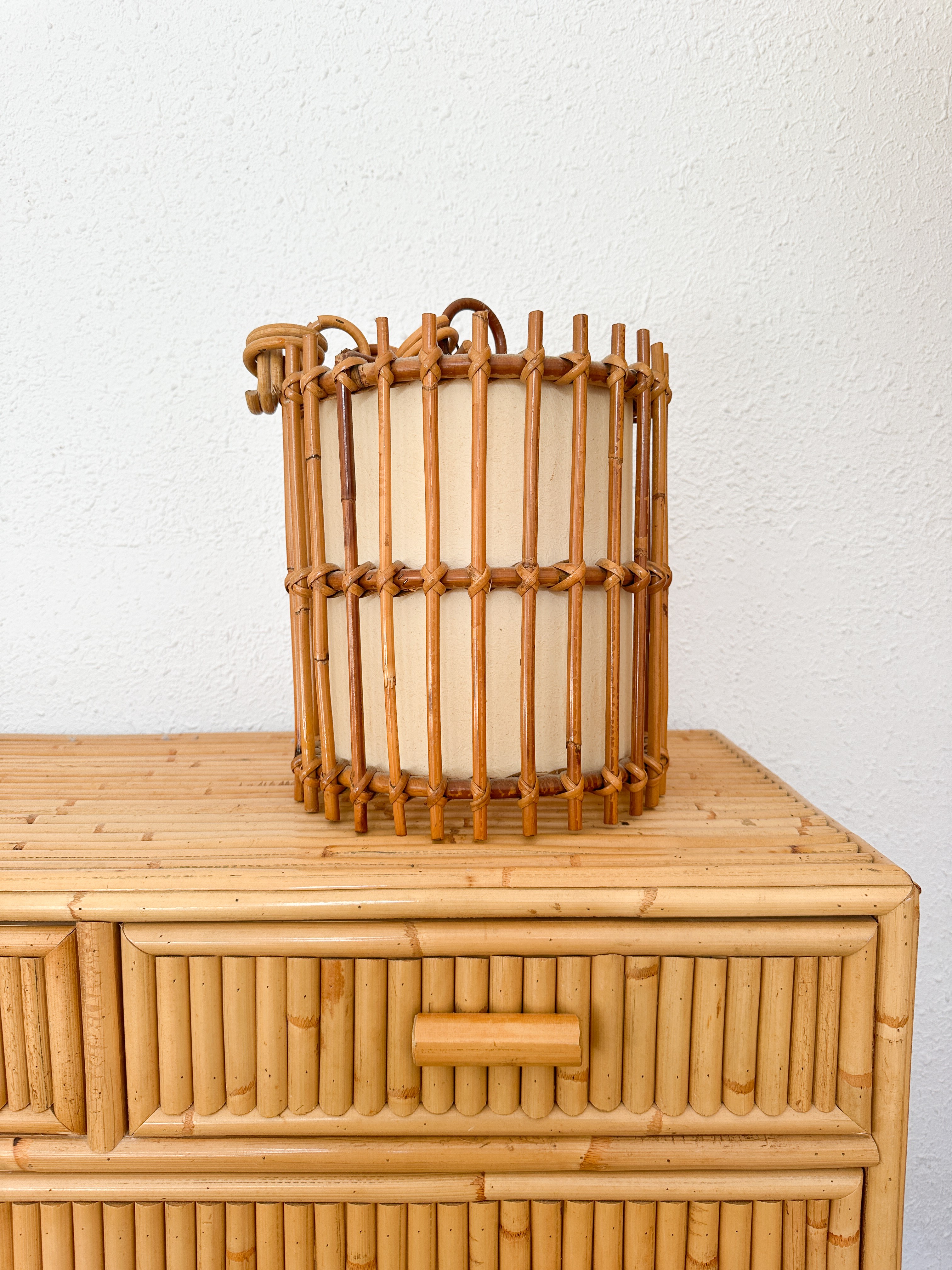 a bamboo basket sitting on top of a wooden dresser