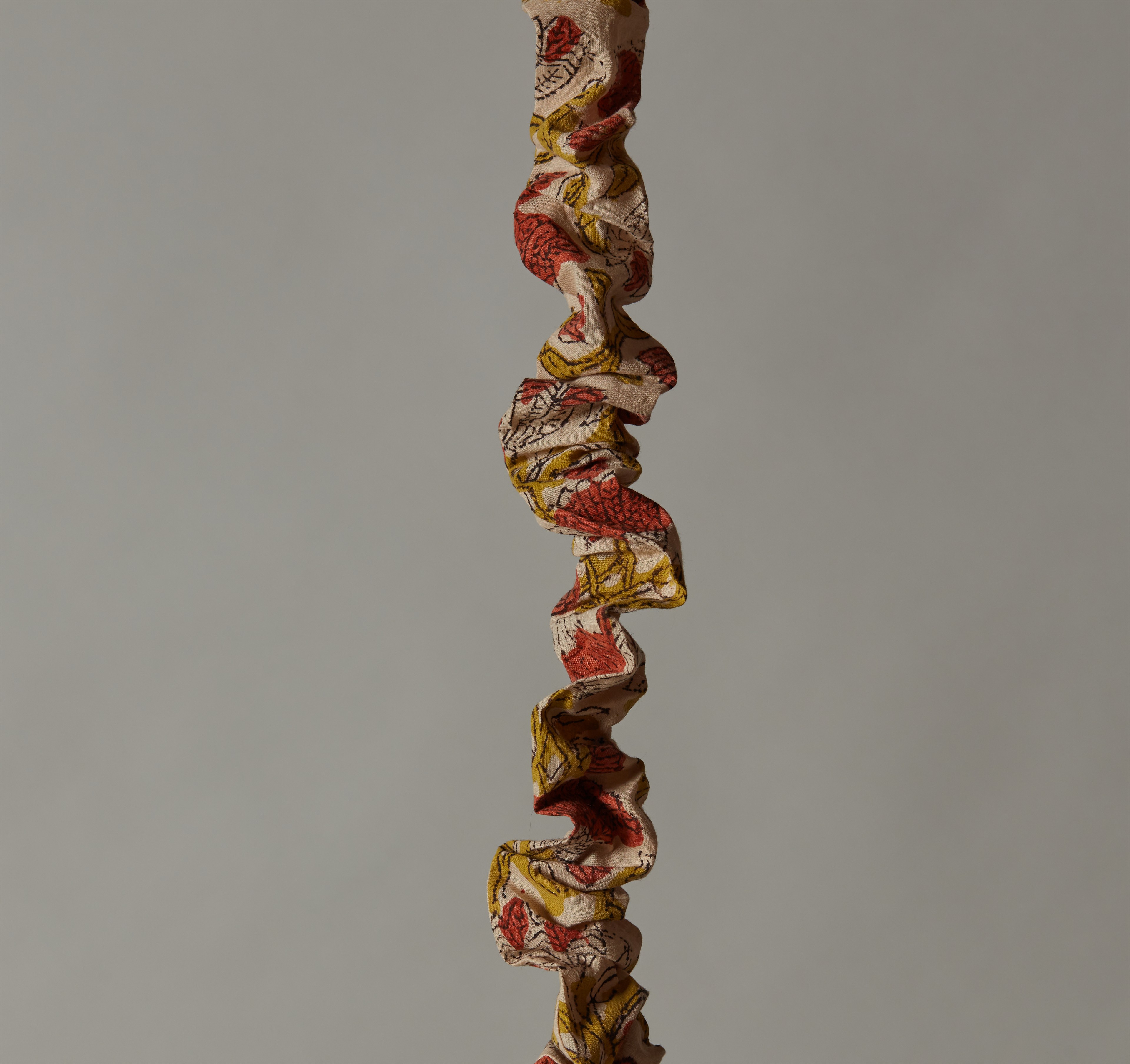 a multicolored necklace hanging from a string