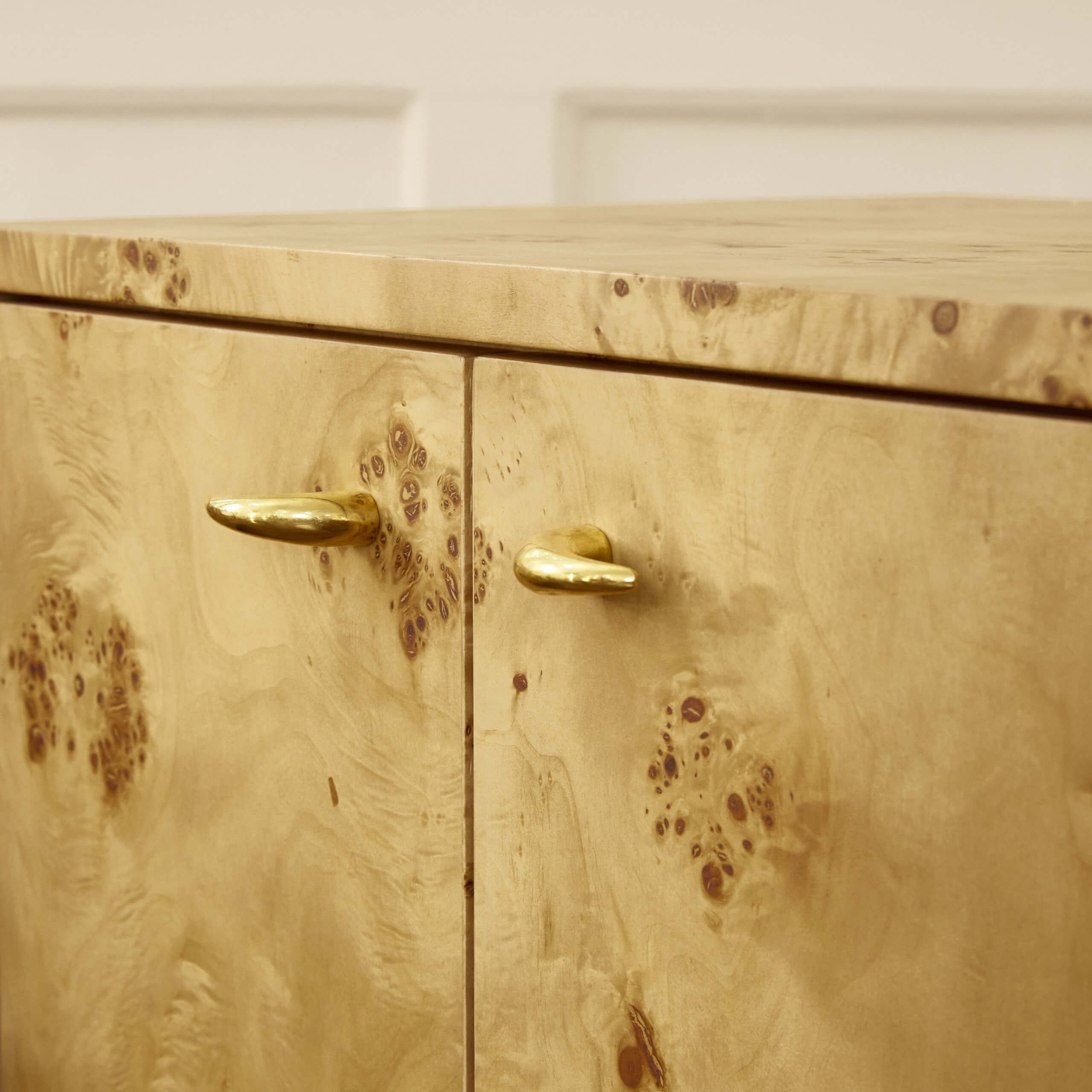 a close up of a wooden cabinet with brass handles