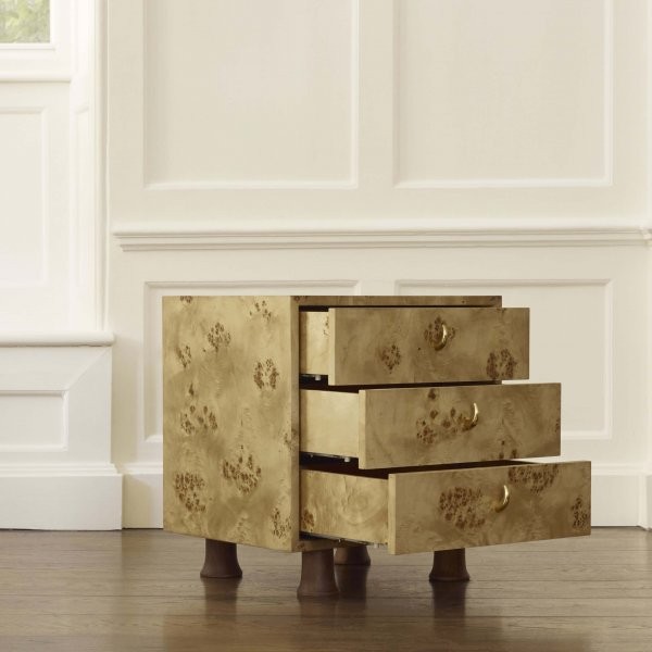 a gold chest of drawers sitting on top of a hard wood floor