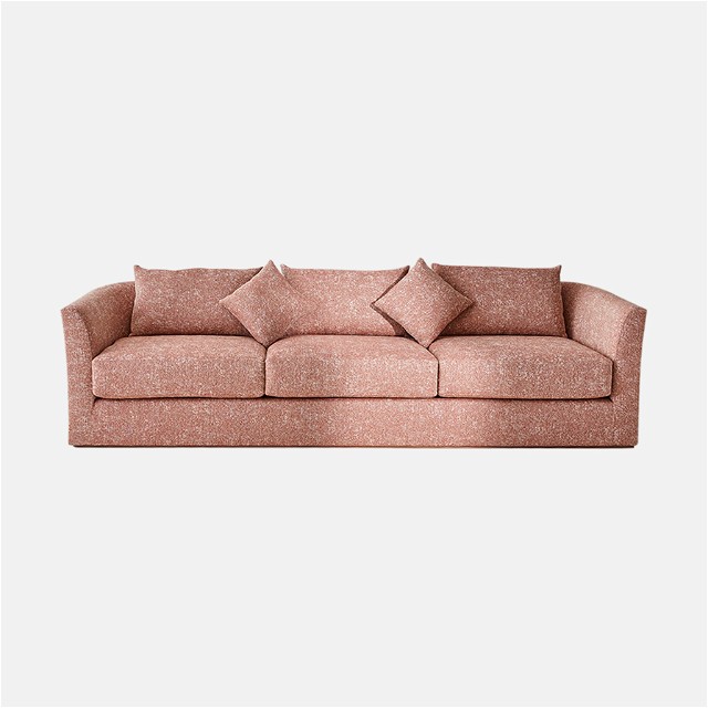 a pink couch with pillows on top of it