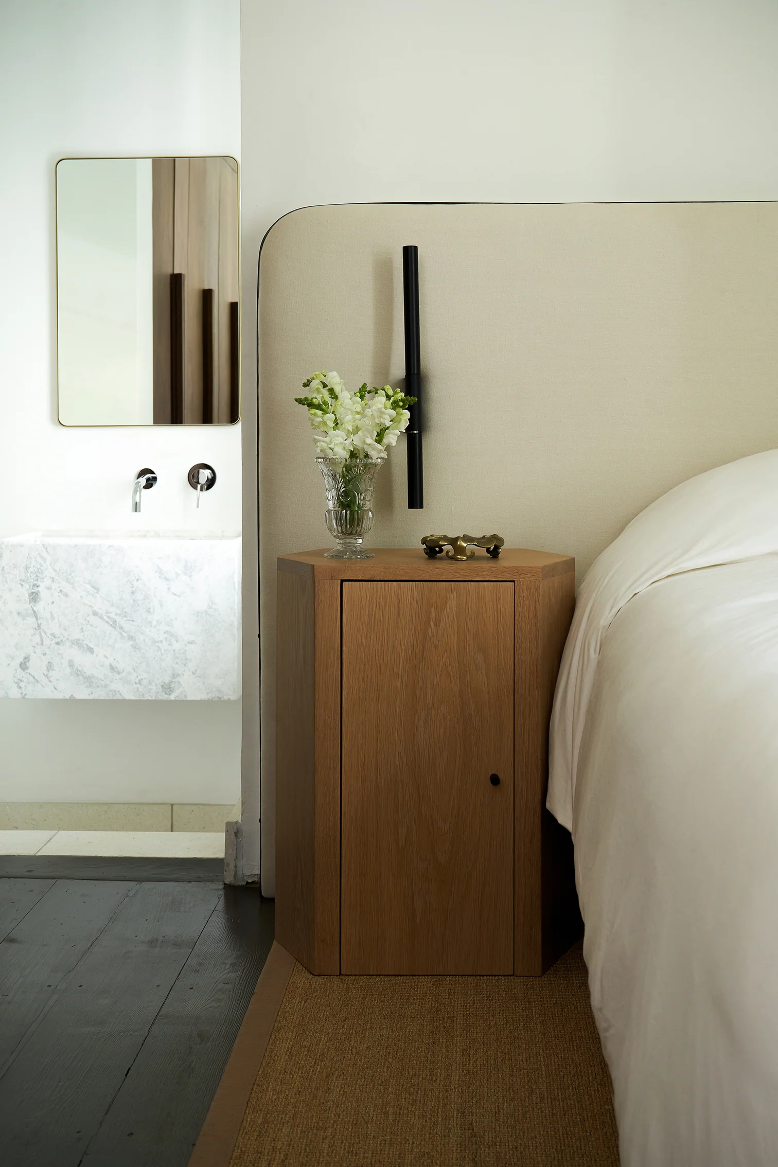 a white bed sitting next to a wooden cabinet