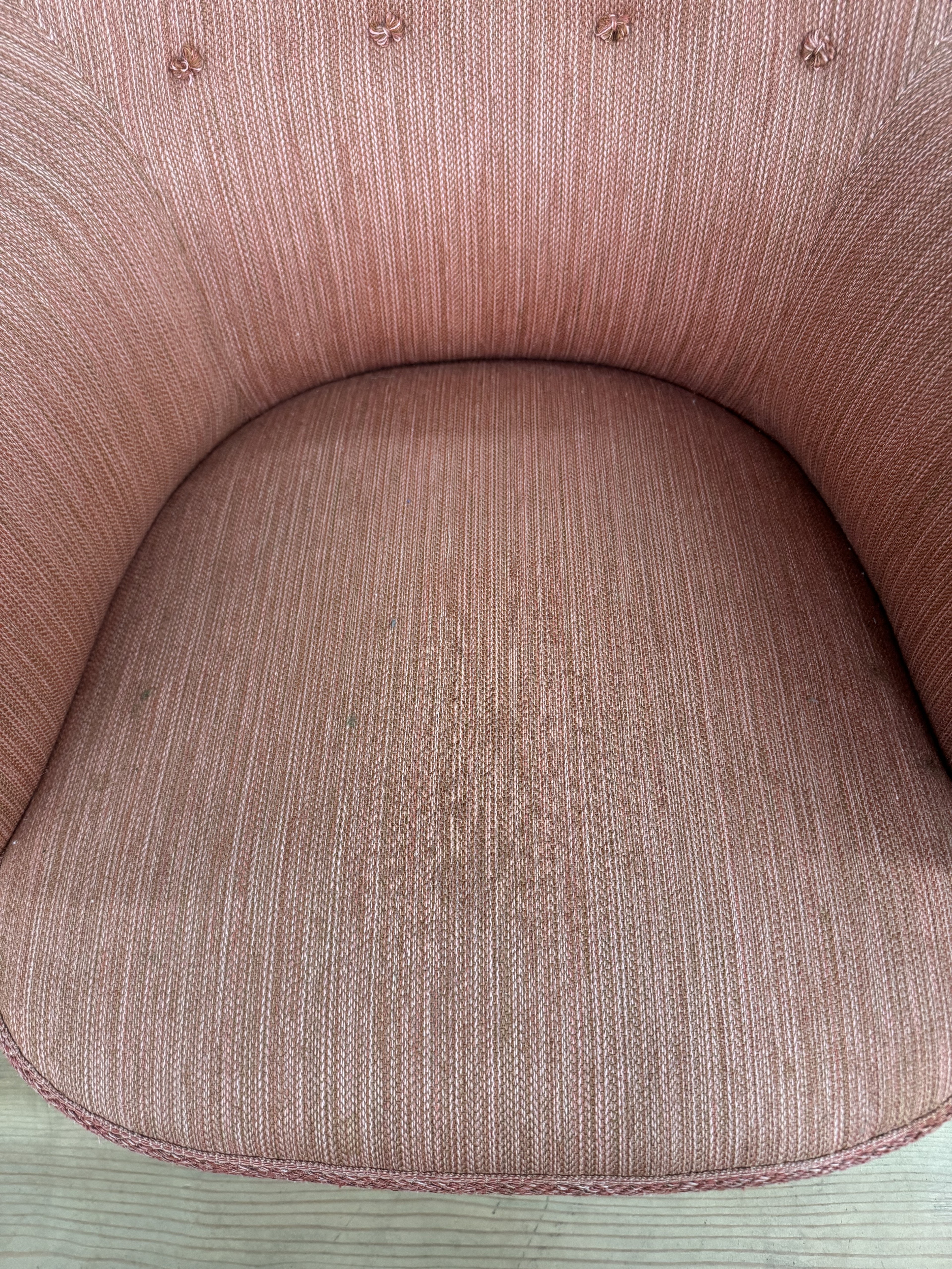 a close up of a pink chair on a wooden floor