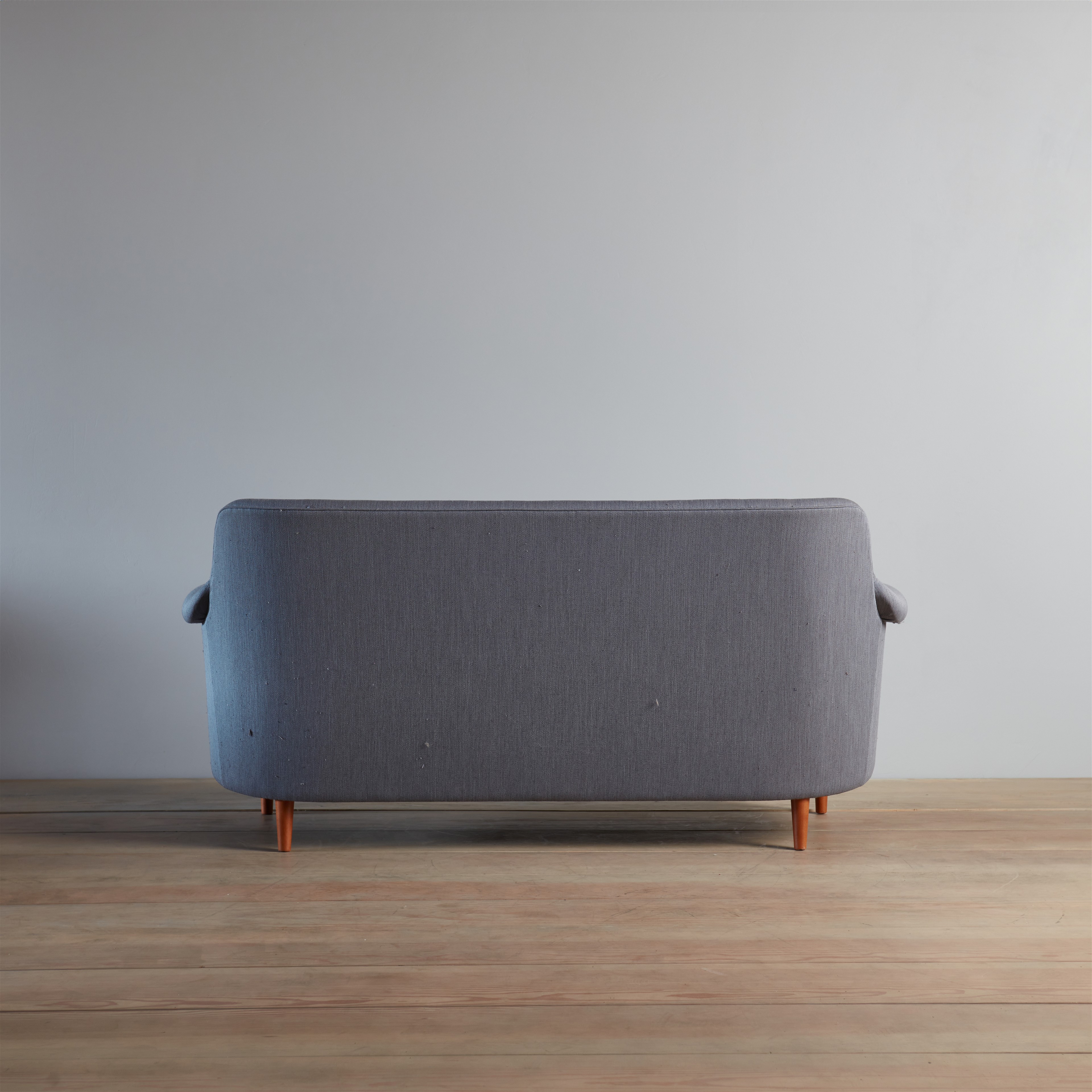 a grey couch sitting on top of a wooden floor