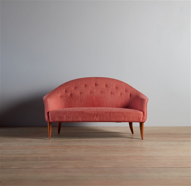 a pink couch sitting on top of a wooden floor