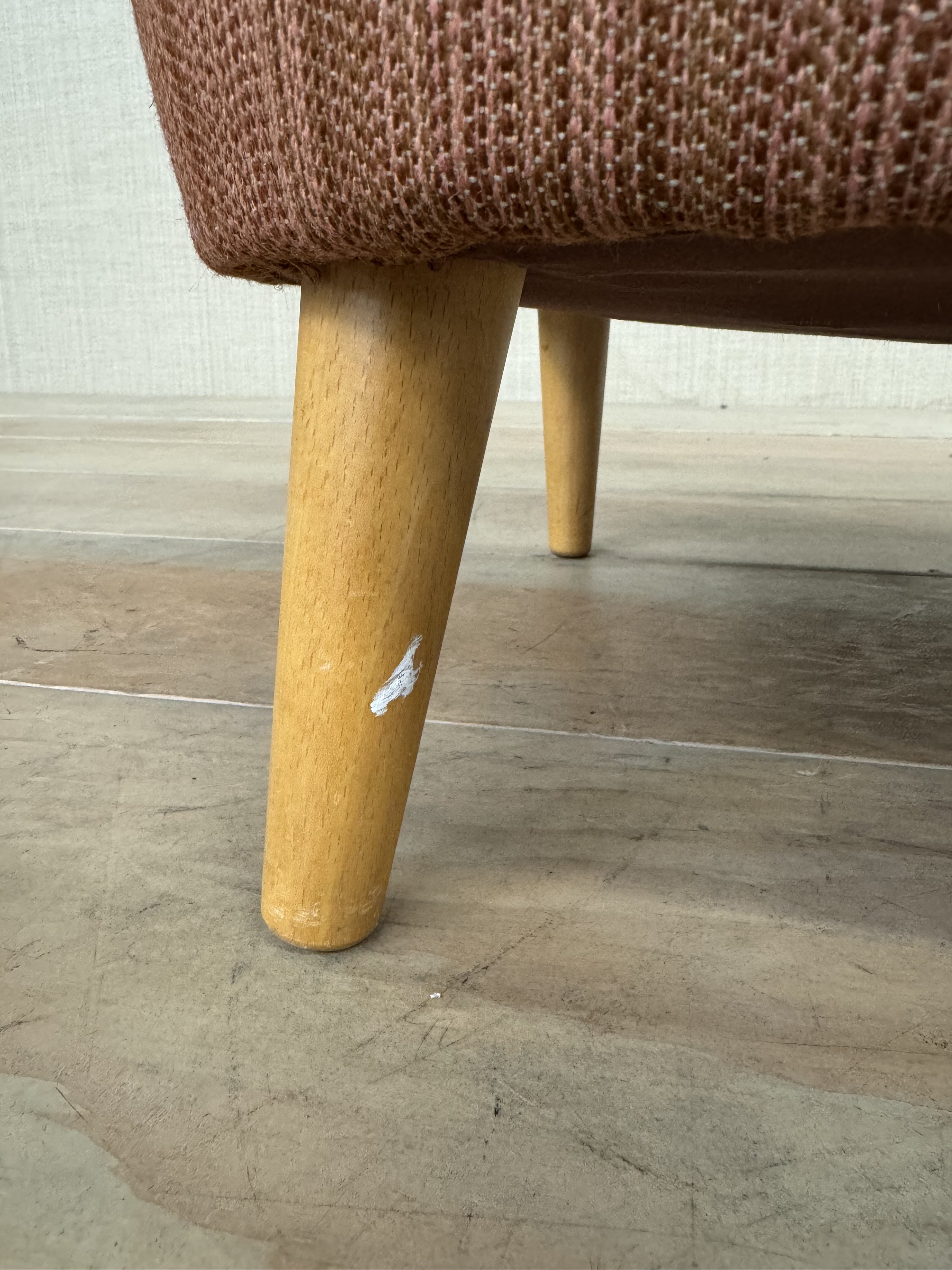 a close up of a wooden bench on a tile floor