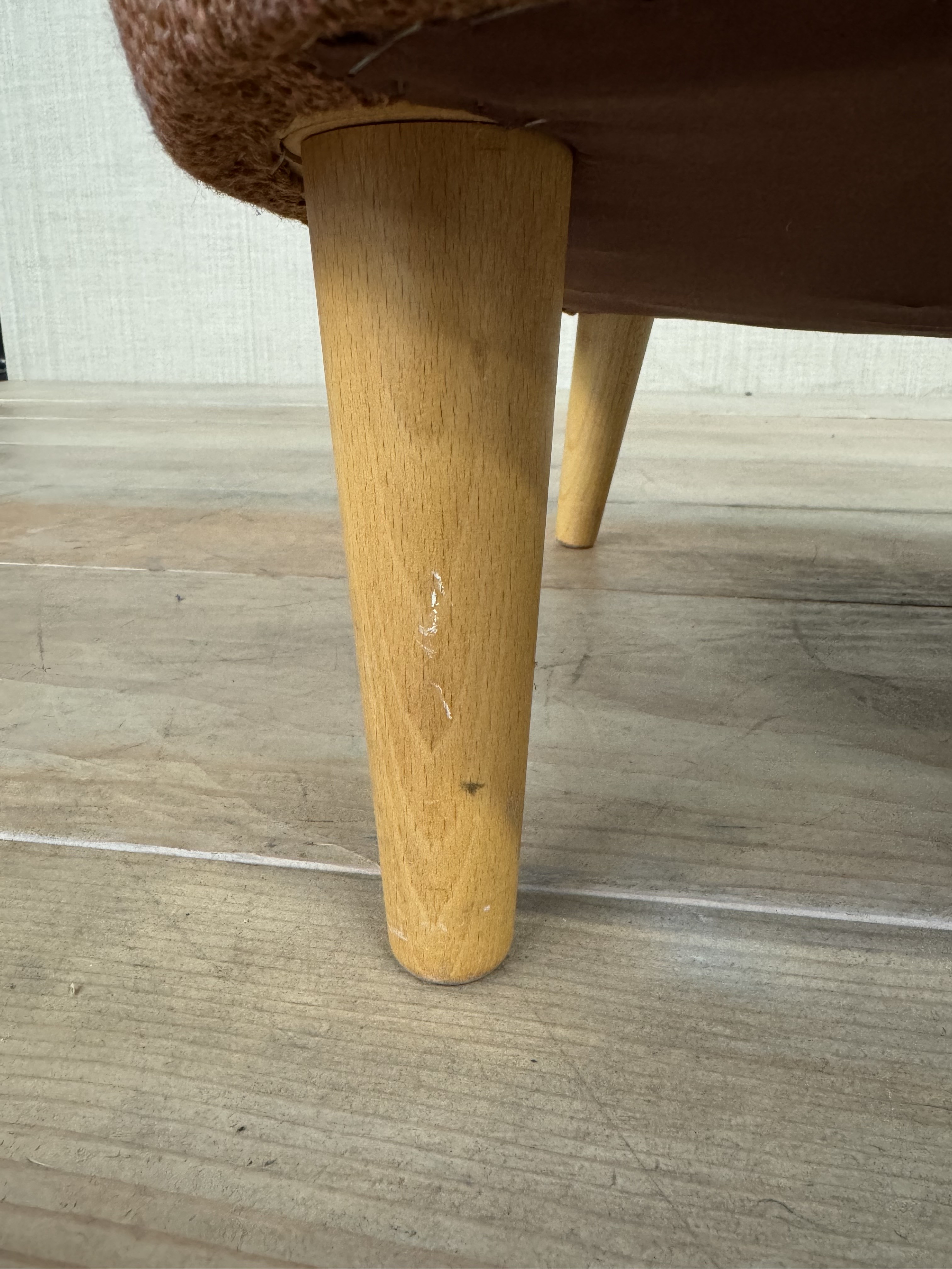 a close up of a wooden chair on a tile floor