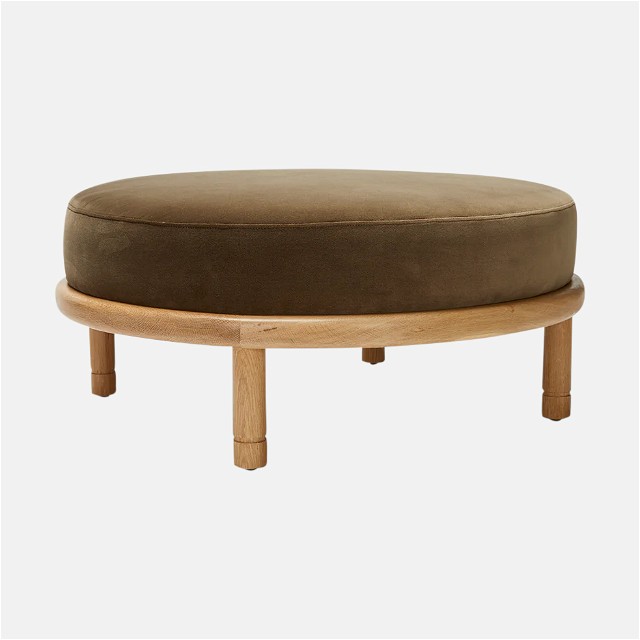a round ottoman sitting on top of a wooden table