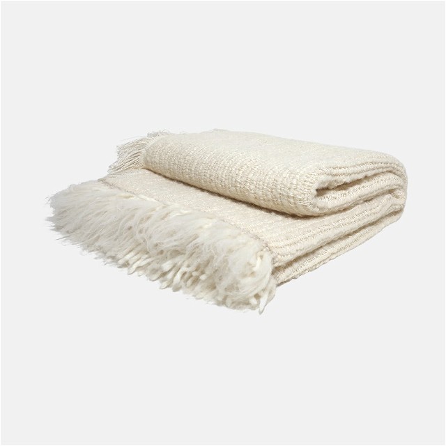 a white blanket with fringes on top of it