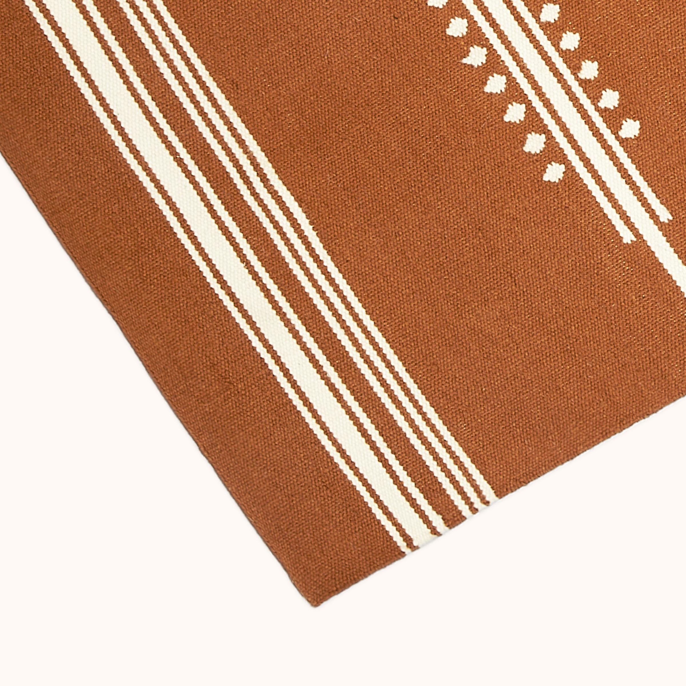 a brown and white striped rug on a white background