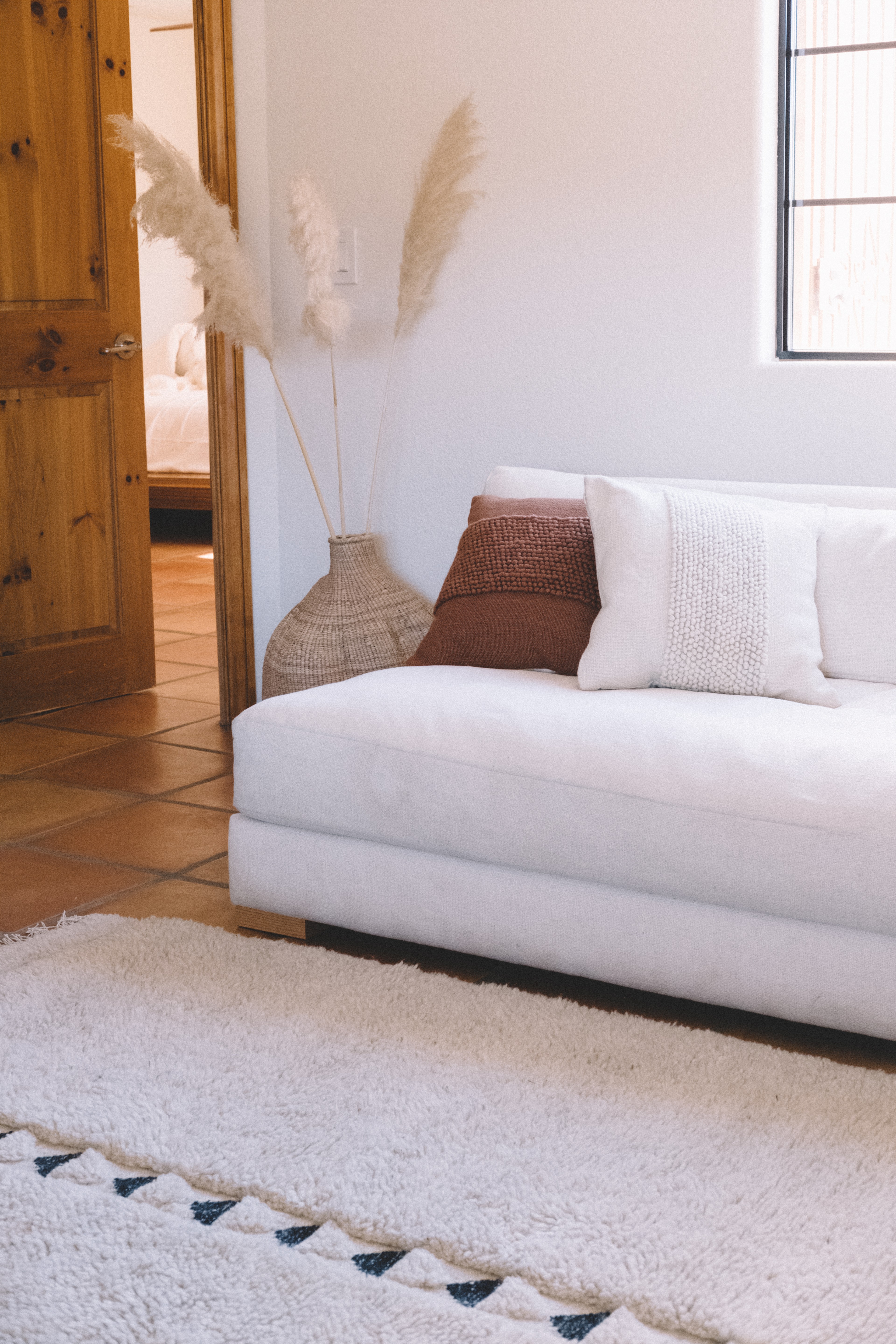 a white couch sitting in a living room next to a white rug