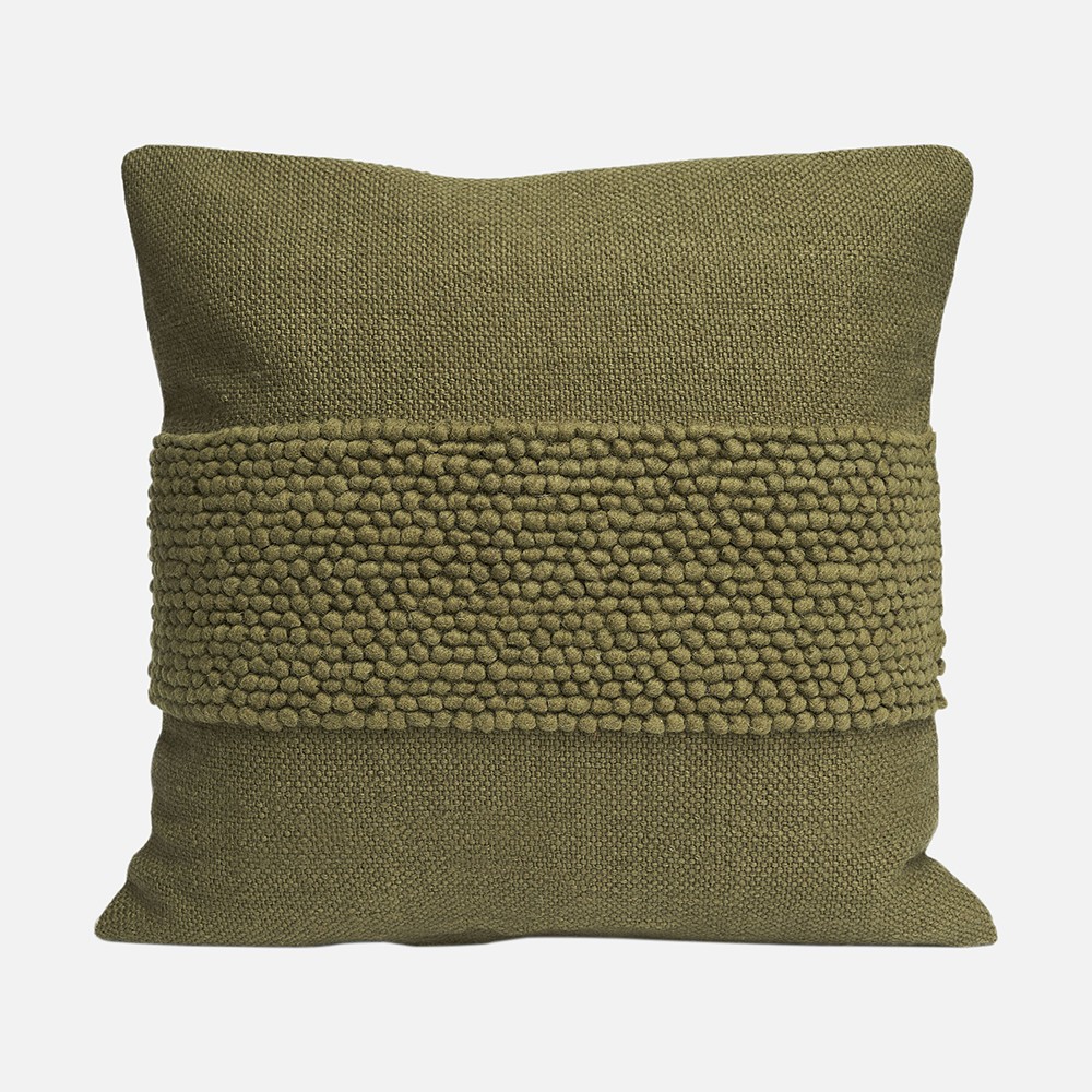a green pillow with braiding on it