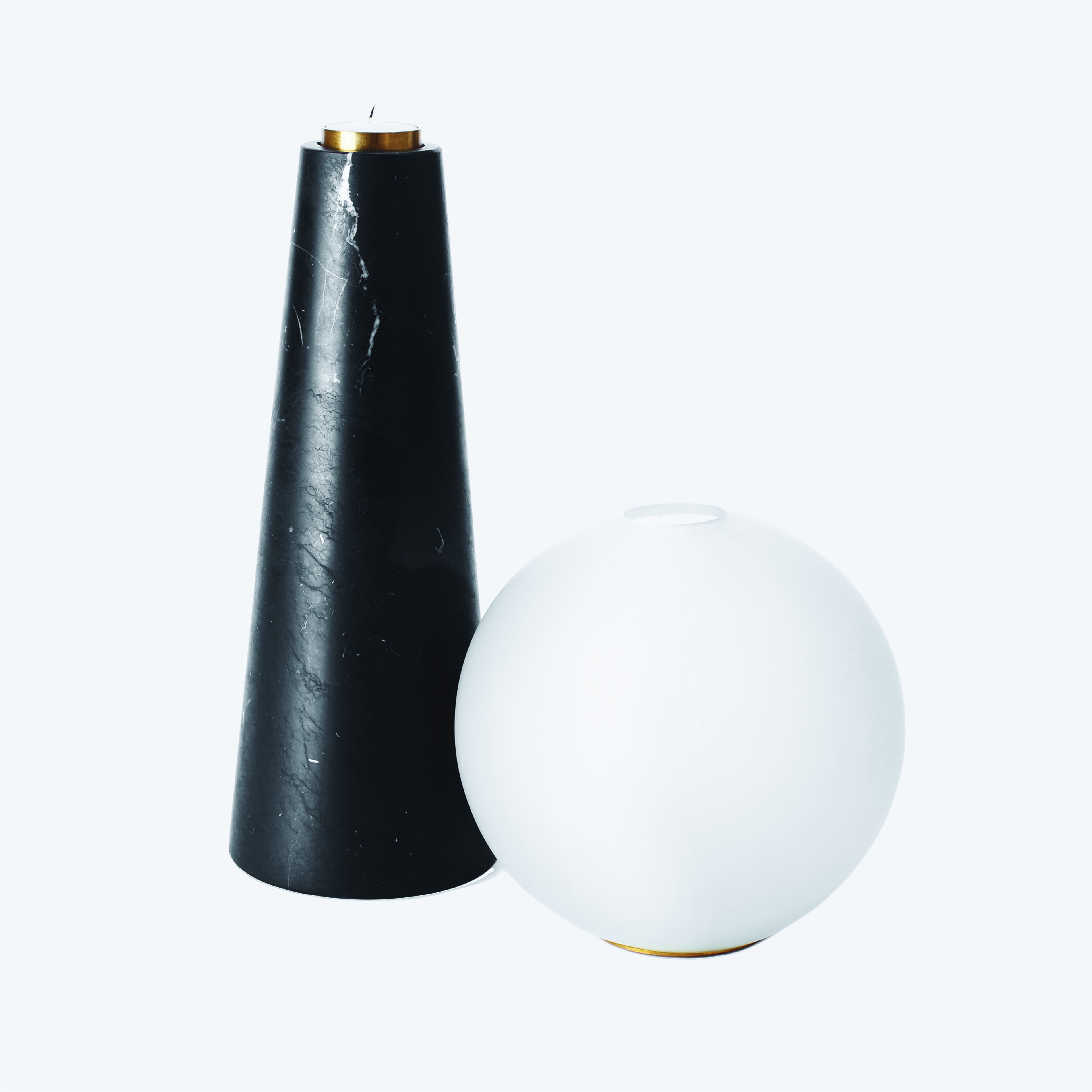 a black and white vase next to a white ball