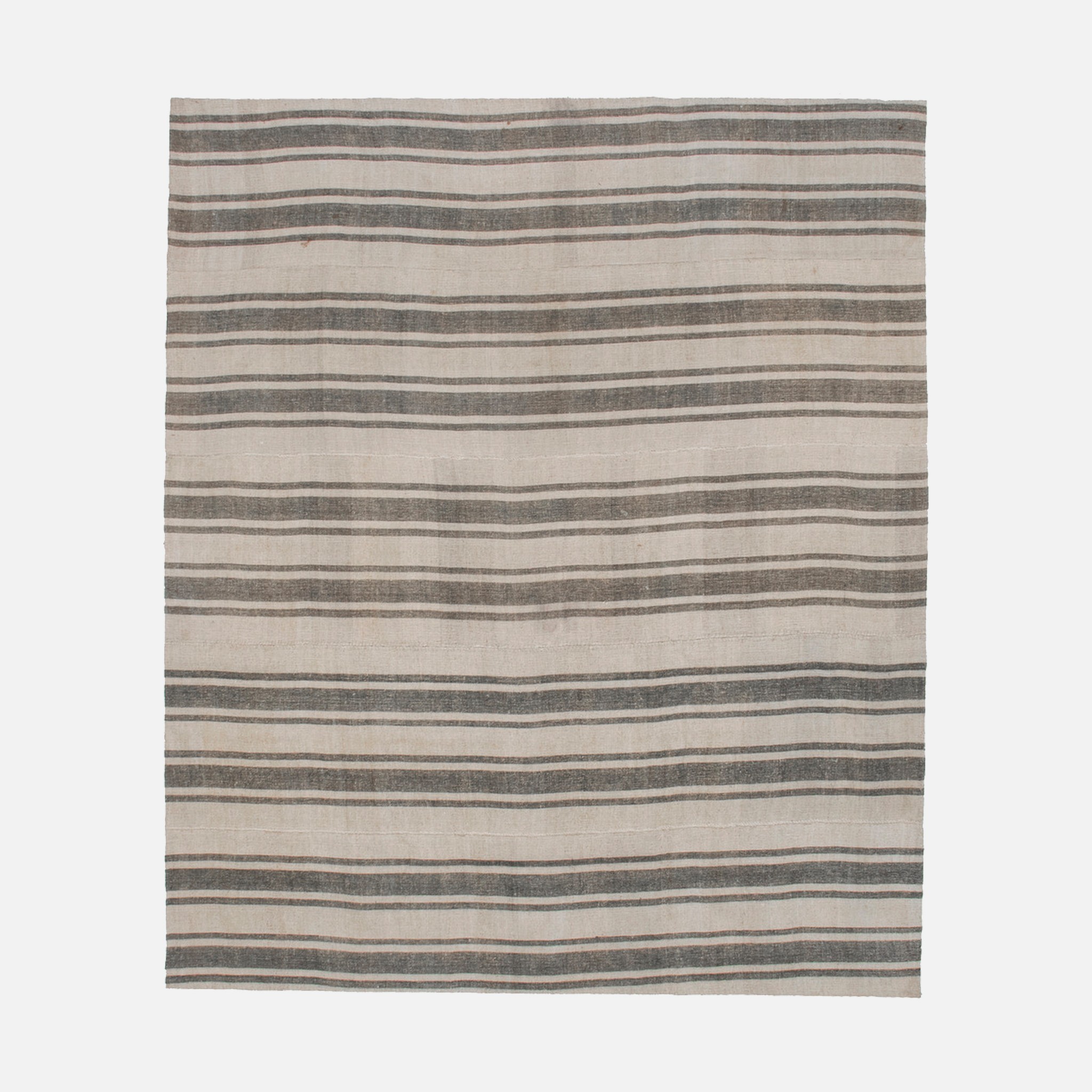 a gray and black striped rug on a white background