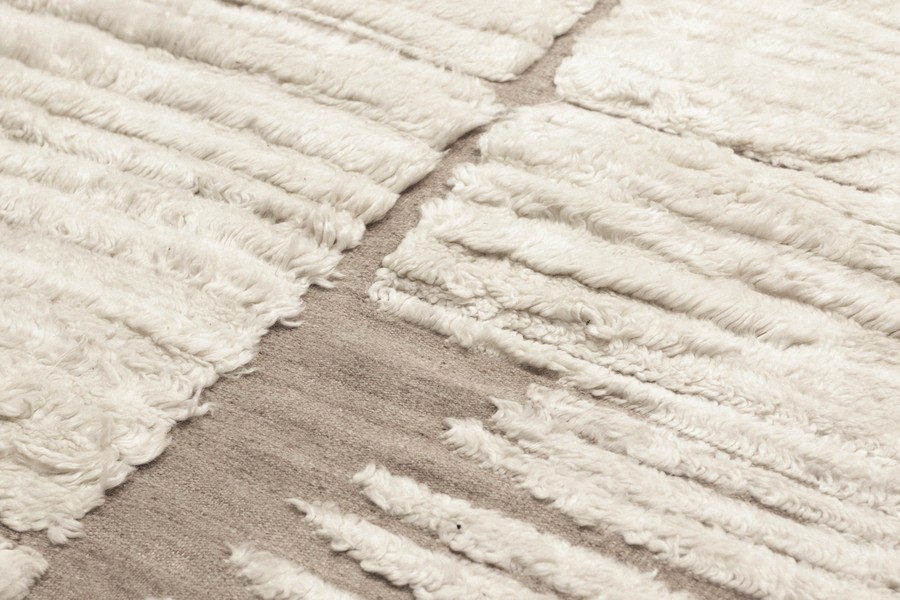 a close up of a white rug with fringes