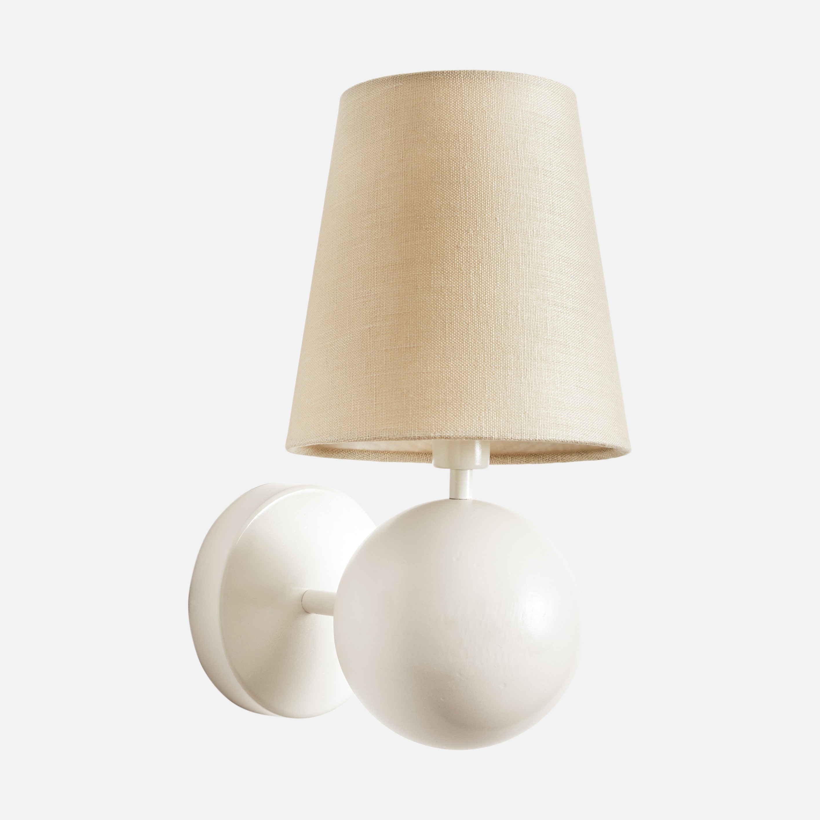 a white wall light with a beige shade on it